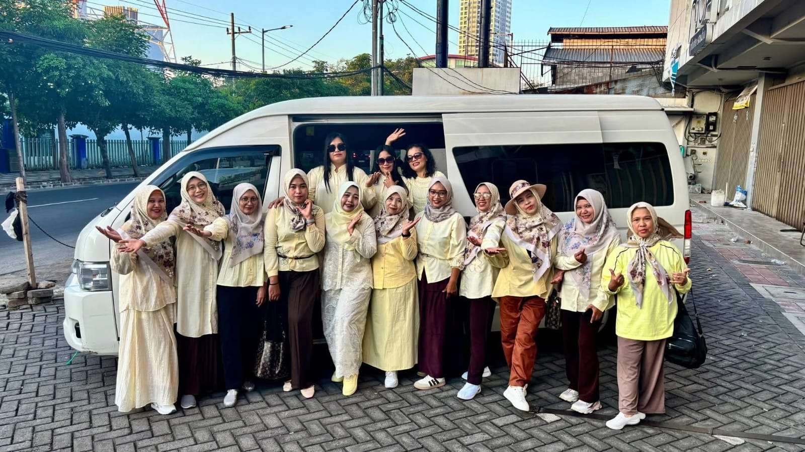 Rombongan ibu-ibu berfoto ceria di depan Toyota Hiace putih R&R Rent Car sebelum berangkat